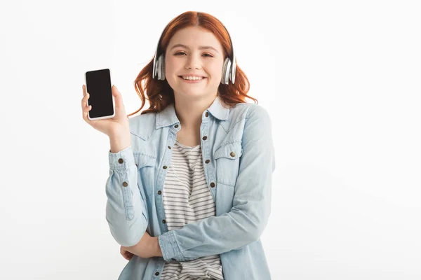 快乐的少女 带着耳机听音乐 用空白屏幕显示智能手机 与白人隔离 — 图库照片