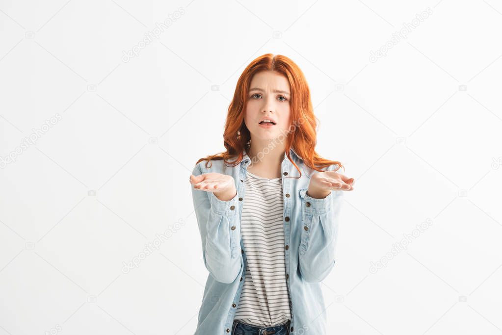 confused redhead teen girl in denim clothes with shrug gesture, isolated on white
