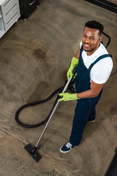 High Angle View Smiling African American Cleaner Vacuuming Floor While — Stock Photo, Image