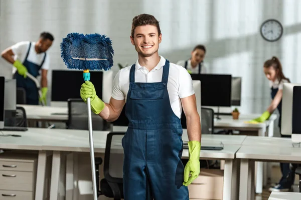 Cheerful Cleaner Holding Mop While Looking Camera Multicultural Colleagues — Stock Photo, Image