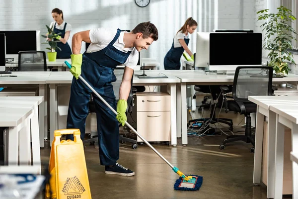 Jovem Sorrindo Chão Lavagem Mais Limpo Com Esfregona Escritório Moderno — Fotografia de Stock