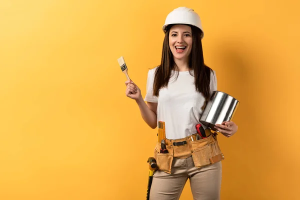 Smiling Handywoman Holding Paint Brush Paint Can Yellow Background — Stock Photo, Image