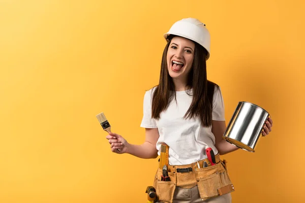 Sorrindo Handywoman Segurando Pincel Pintura Lata Tinta Fundo Amarelo — Fotografia de Stock