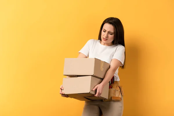 Cansada Reparadora Segurando Caixas Papelão Fundo Amarelo — Fotografia de Stock