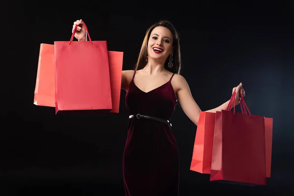 Gülümseyen Kadın Siyah Arka Planda Alışveriş Torbaları Taşıyor — Stok fotoğraf