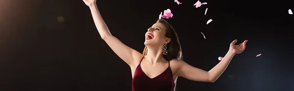 Panoramic Shot Smiling Woman Standing Falling Confetti Black Background — Stock Photo, Image