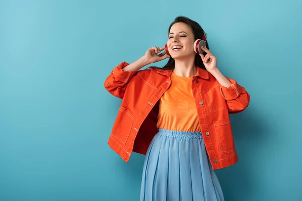 Mujer Sonriente Con Auriculares Escuchando Música Sobre Fondo Azul — Foto de Stock