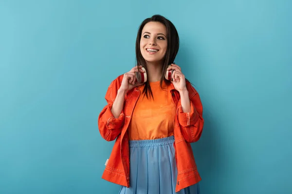 Mujer Sonriente Con Auriculares Mirando Hacia Otro Lado Sobre Fondo — Foto de Stock