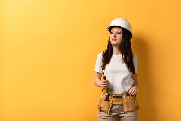 Attractive Handywoman Holding Screwdriver Looking Away Yellow Background — Stock Photo, Image