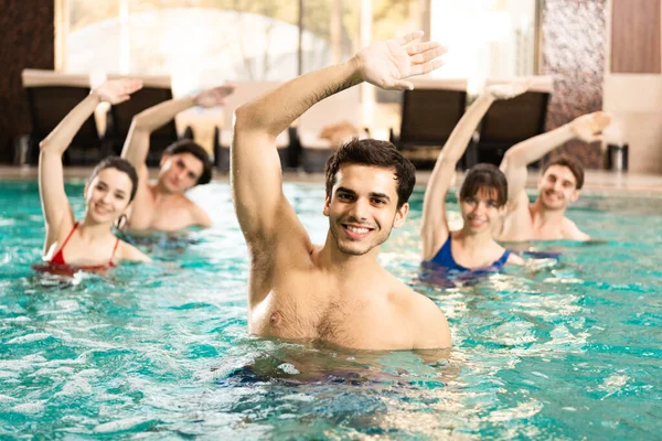 Foco Seletivo Formador Bonito Sorrindo Para Câmera Enquanto Exercita Com — Fotografia de Stock