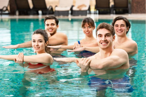 Foco Seletivo Dos Jovens Sorrindo Para Câmera Durante Aeróbica Aquática — Fotografia de Stock