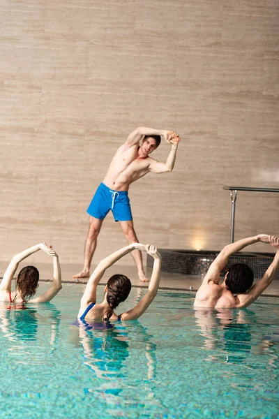 젊은이들 이물에어 수영장에서 훈련시키는 조련사 — 스톡 사진