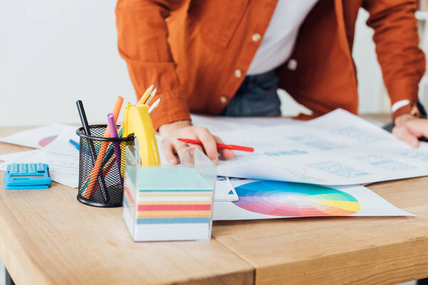 Selective focus of developer planning with user experience design of website near color circle on table