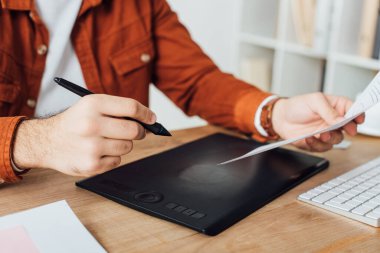 Ofiste kullanıcı deneyimi tasarımı planlarken grafik tableti kullanan ux tasarımcısının kırpılmış görünümü