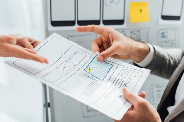 Ofisteki beyaz tahtanın yanında web sitesi ux tasarımı projesinde çalışan tasarımcıların kırpılmış görünümü 