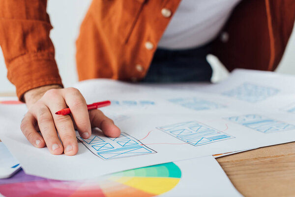 Selective focus of developer planning app sketches for user experience design on table isolated on grey