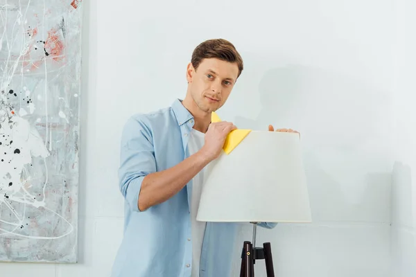 Handsome Man Looking Camera While Cleaning Floor Lamp Rag Home — Stock Photo, Image