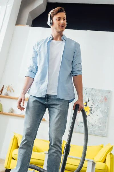 Low Angle View Smiling Man Headphones Using Vacuum Cleaner Home — Stock Photo, Image