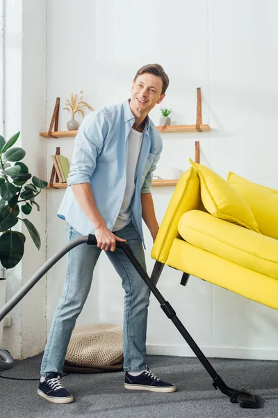 Homme Souriant Regardant Loin Tout Nettoyant Tapis Avec Aspirateur Sous — Photo