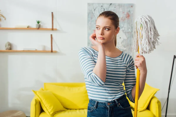 Pensiv Kvinna Som Håller Mopp Och Tittar Bort Hemma — Stockfoto