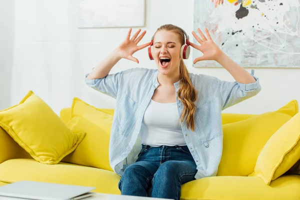 Schöne Frau Mit Kopfhörern Singt Auf Sofa Wohnzimmer — Stockfoto