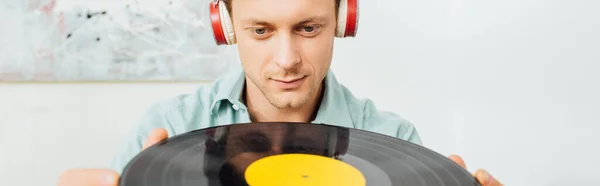 Panoramaaufnahme Eines Gutaussehenden Mannes Mit Kopfhörern Der Schallplatte Wohnzimmer Hält — Stockfoto