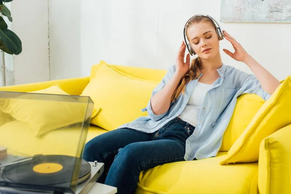 Όμορφη Γυναίκα Ακούγοντας Μουσική Ακουστικά Κοντά Πικάπ Στο Σαλόνι — Φωτογραφία Αρχείου