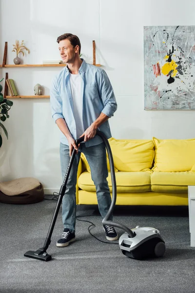 Smiling Man Looking Away While Cleaning Carpet Vacuum Cleaner Home — Stock Photo, Image