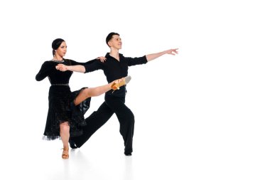 Siyah elbiseli ve takım elbiseli dansçı çift beyazlar içinde soyutlanmış dans ediyorlar.