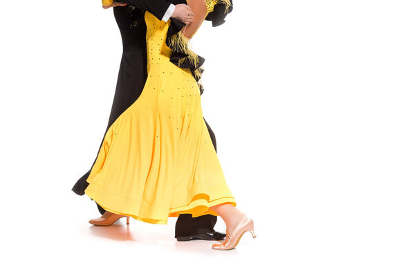 обрезанный вид элегантной молодой пары бальных танцоров, танцующих на белом
