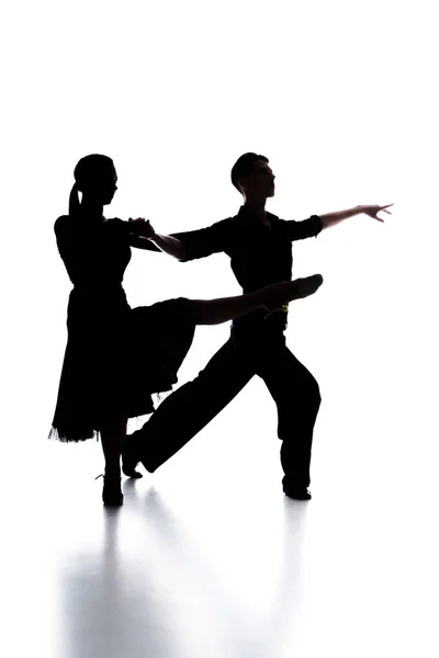 silhouettes of elegant couple of ballroom dancers dancing on white