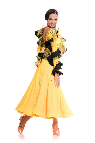 Улыбающаяся элегантная молодая танцовщица в желтом платье, танцующая отдельно на белом
