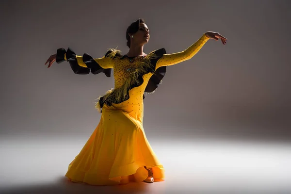 Улыбающаяся Элегантная Молодая Танцовщица Желтом Платье Танцует Темноте — стоковое фото