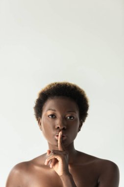 Gri üzerinde izole edilmiş sessizlik sembolü gösteren Afro-Amerikalı çekici bir kız.