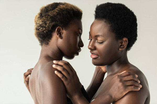 Nude african american women hugging isolated on grey