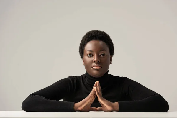 Mujer Afroamericana Reflexiva Cuello Alto Negro Sentada Mesa Aislada Gris — Foto de Stock