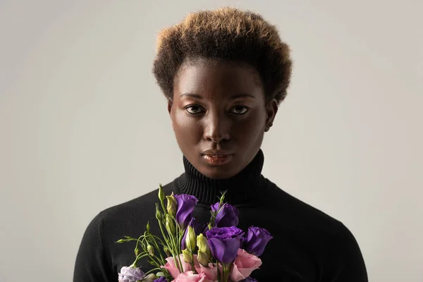 Afrikanerin Mit Schwarzem Rollkragen Hält Eustoma Blüten Isoliert Auf Grau — Stockfoto