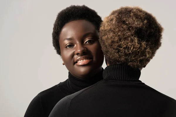 Sonrientes Chicas Afroamericanas Cuellos Altos Negros Abrazándose Aisladas Gris — Foto de Stock