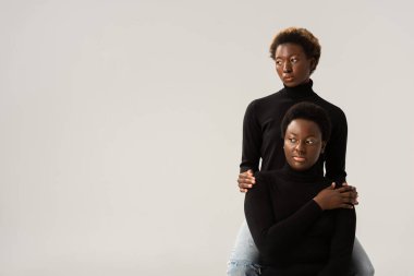 Siyahi balıkçı yaka kazaklı Afro-Amerikan dostları Gri 'de izole edilmiş bir şekilde sarılıyorlar