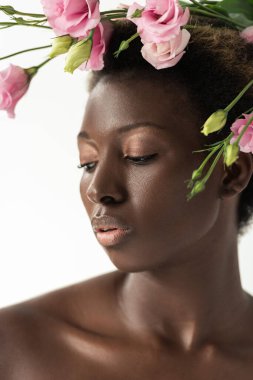 Beyaz tenli, pembe Eustoma çiçekleri olan çıplak Afrikalı Amerikalı kadın.