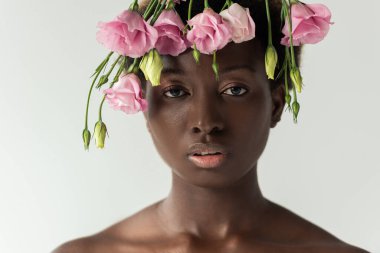 Çekici, çıplak, Afro-Amerikalı, pembe Eustoma çiçekleri olan kadın. Gri renkte izole edilmiş.