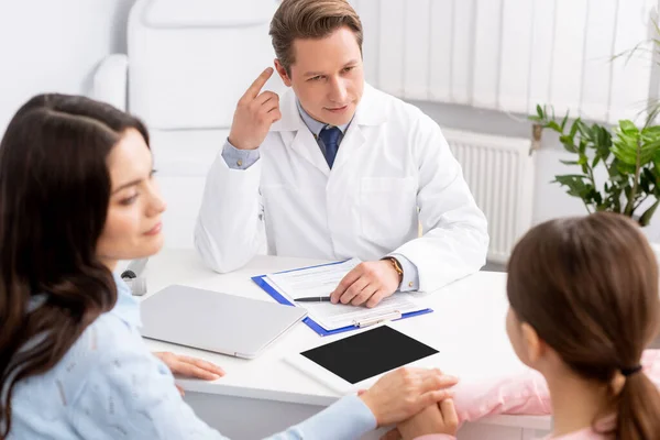 Ent Physician Pointing Finger Ear Mother Daughter Sitting Desk — Stock Photo, Image