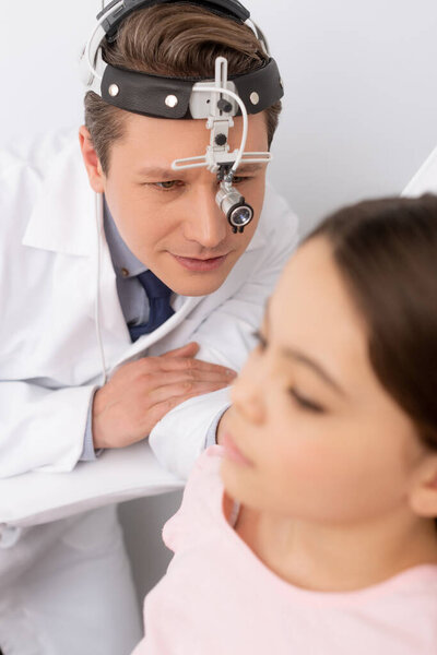 selective focus of ent physician examining eat of cute kid