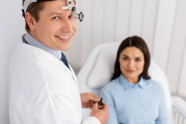 耳元で耳鼻咽喉科医の笑顔の選択的焦点椅子に座っている笑顔の女性の近くに耳鼻咽喉科医 — ストック写真