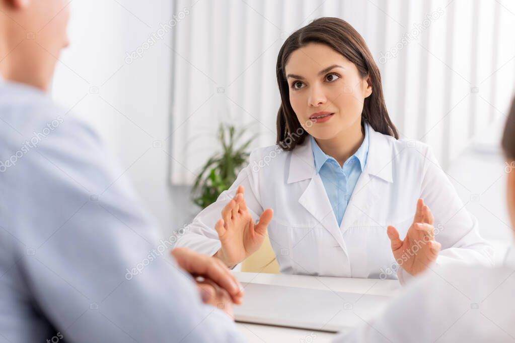 selective focus of attractive ent physician talking to patients