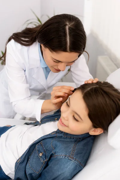 细心的耳鼻喉科医生检查可爱儿童耳朵的高角镜 — 图库照片