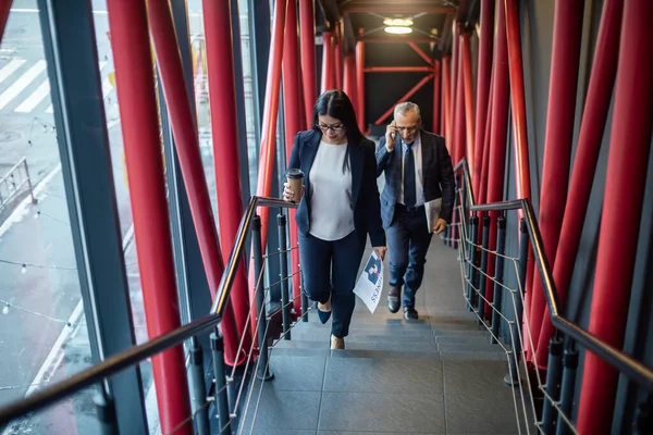 ビジネスマンがスマートフォンやアジア人のビジネスマンに紙コップを持って階段を歩き — ストック写真