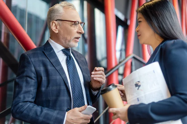 Zakenman Met Smartphone Aziatische Zakenvrouw Met Papieren Beker Praten Kijken — Stockfoto