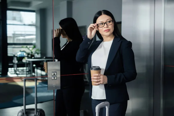 Азиатская Деловая Женщина Бумажной Чашкой Глядя Сторону Стоя Рядом Лифтом — стоковое фото
