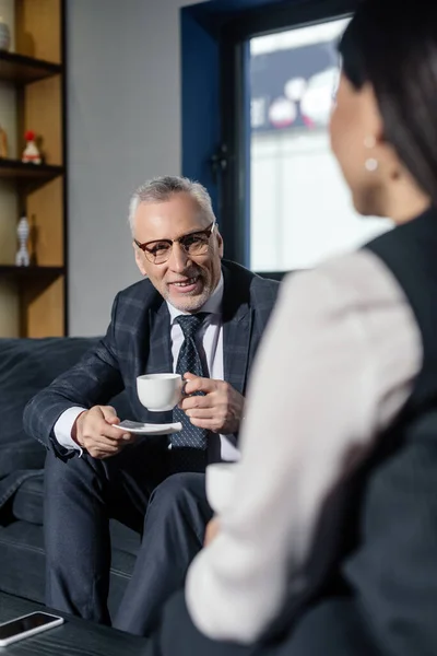 Enfoque Selectivo Del Hombre Negocios Sonriente Sosteniendo Taza Hablando Con — Foto de Stock